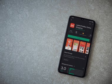 Lod, Israel - 8 Temmuz 2020: Seramik taştan arka planda siyah bir cep telefonunun ekranında uygulamalı oyun mağazası sayfasını aydınlat. Üst görünüm düzlüğü kopyalama alanı ile yatıyordu.