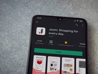 Lod, Israel - 8 Temmuz 2020: Seramik taş zemin üzerinde siyah bir cep telefonu ekranında Joom uygulaması oyun mağazası sayfası. Üst görünüm düzlüğü kopyalama alanı ile yatıyordu.