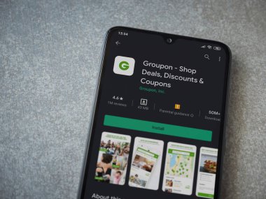 Lod, Israel - 8 Temmuz 2020: Groupon uygulaması oyun mağazası sayfası seramik taş zemin üzerinde siyah bir cep telefonu görüntüsü. Üst görünüm düzlüğü kopyalama alanı ile yatıyordu.