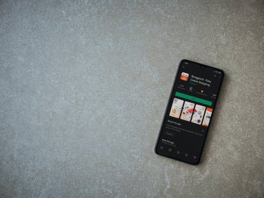 Lod, Israel - 8 Temmuz 2020: Seramik taş zemin üzerinde siyah bir cep telefonunun sergilendiği Banggood uygulaması oyun mağazası sayfası. Üst görünüm düzlüğü kopyalama alanı ile yatıyordu.