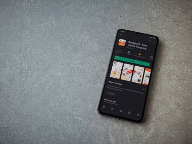 Lod, Israel - 8 Temmuz 2020: Seramik taş zemin üzerinde siyah bir cep telefonunun sergilendiği Banggood uygulaması oyun mağazası sayfası. Üst görünüm düzlüğü kopyalama alanı ile yatıyordu.