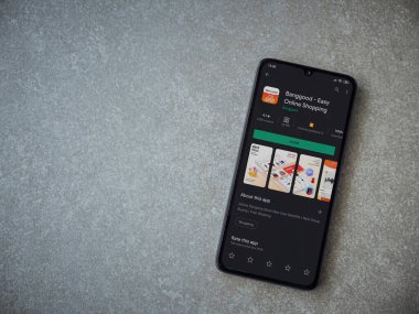 Lod, Israel - 8 Temmuz 2020: Seramik taş zemin üzerinde siyah bir cep telefonunun sergilendiği Banggood uygulaması oyun mağazası sayfası. Üst görünüm düzlüğü kopyalama alanı ile yatıyordu.