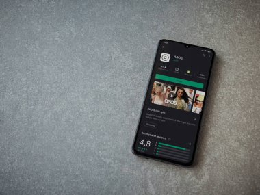 Lod, Israel - 8 Temmuz 2020: ASOS uygulama oyun mağazası sayfası seramik taş zemin üzerinde siyah bir cep telefonu görüntüsü. Üst görünüm düzlüğü kopyalama alanı ile yatıyordu.