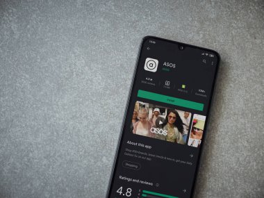 Lod, Israel - 8 Temmuz 2020: ASOS uygulama oyun mağazası sayfası seramik taş zemin üzerinde siyah bir cep telefonu görüntüsü. Üst görünüm düzlüğü kopyalama alanı ile yatıyordu.