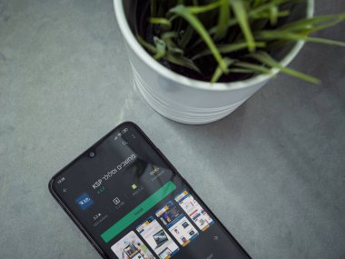 Lod, Israel - 8 Temmuz 2020: Modern minimalist ofis çalışma alanı ve siyah cep telefonu ile KSP uygulama oyun mağazası sayfası mermer zemin üzerinde. Üst görünüm düzlüğü kopyalama alanı ile yatıyordu.