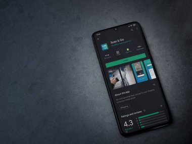 Lod, Israel - 8 Temmuz 2020: Koyu mermer taştan arka planda siyah bir cep telefonunun ekranında uygulamalı oyun mağazası sayfasını tara. Üst görünüm düzlüğü kopyalama alanı ile yatıyordu.