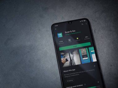 Lod, Israel - 8 Temmuz 2020: Koyu mermer taştan arka planda siyah bir cep telefonunun ekranında uygulamalı oyun mağazası sayfasını tara. Üst görünüm düzlüğü kopyalama alanı ile yatıyordu.