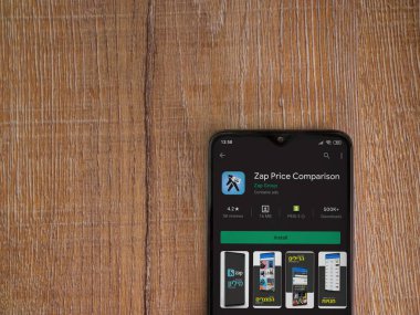Lod, Israel - 8 Temmuz 2020: Zap Price Karşılaştırma uygulaması oyun mağazası sayfası ahşap arka planda siyah bir cep telefonu ekranında. Üst görünüm düzlüğü kopyalama alanı ile yatıyordu.