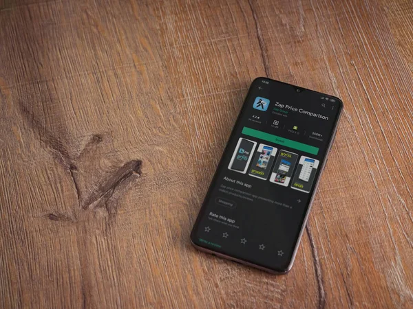 Lod, Israel - 8 Temmuz 2020: Zap Price Karşılaştırma uygulaması oyun mağazası sayfası ahşap arka planda siyah bir cep telefonu ekranında. Üst görünüm düzlüğü kopyalama alanı ile yatıyordu.