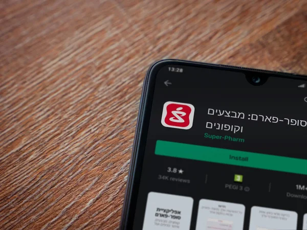 Lod, Israel - 8 Temmuz 2020: Süper Pharm uygulama oyun mağazası sayfası ahşap arka planda siyah bir cep telefonunun ekranında. Üst görünüm düzlüğü kopyalama alanı ile yatıyordu.