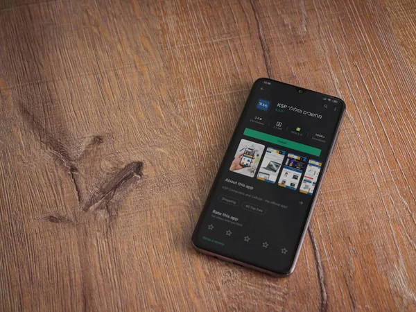 Lod, Israel - 8 Temmuz 2020: KSP uygulama oyun mağazası sayfası ahşap arka planda siyah bir cep telefonunun ekranında. Üst görünüm düzlüğü kopyalama alanı ile yatıyordu.