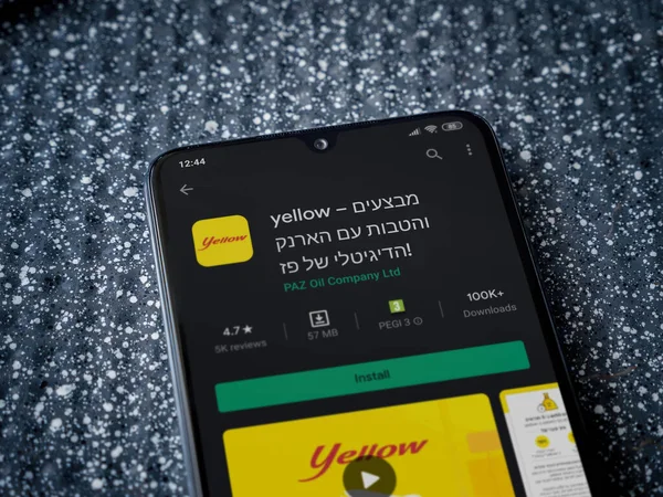 Lod, Israel - 8 Temmuz 2020: Metalik arka planda siyah bir cep telefonunun sergilendiği sarı uygulama oyun mağazası sayfası. Üst görünüm yatağını kapat.