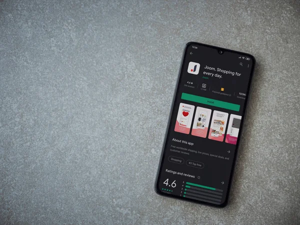 Lod, Israel - 8 Temmuz 2020: Seramik taş zemin üzerinde siyah bir cep telefonu ekranında Joom uygulaması oyun mağazası sayfası. Üst görünüm düzlüğü kopyalama alanı ile yatıyordu.
