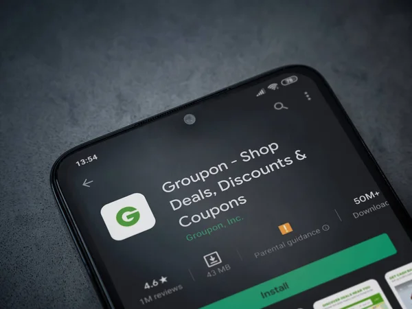 Lod, Israel - 8 Temmuz 2020: Groupon uygulaması oyun mağazası sayfası koyu mermer taştan arka planda siyah bir cep telefonunun ekranında. Üst görünüm düzlüğü kopyalama alanı ile yatıyordu.
