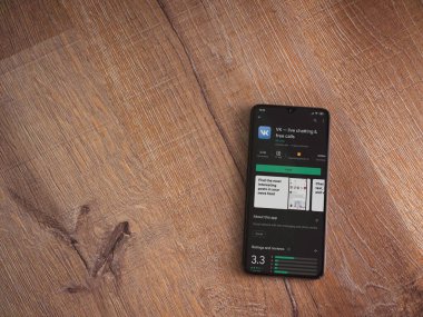 Lod, Israel - 8 Temmuz 2020: VK uygulama oyun mağazası sayfası ahşap arka planda siyah bir cep telefonunun ekranında. Üst görünüm düzlüğü kopyalama alanı ile yatıyordu.