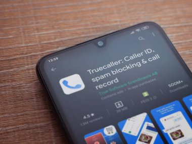 Lod, Israel - 8 Temmuz 2020: Truecaller uygulama oyun mağazası sayfası ahşap arka planda siyah bir cep telefonunun ekranında. Üst görünüm düzlüğü kopyalama alanı ile yatıyordu.