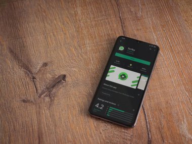 Lod, Israel - 8 Temmuz 2020: Scriby uygulama oyun mağazası sayfası ahşap arka planda siyah bir cep telefonunun ekranında. Üst görünüm düzlüğü kopyalama alanı ile yatıyordu.