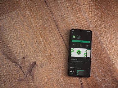 Lod, Israel - 8 Temmuz 2020: Scriby uygulama oyun mağazası sayfası ahşap arka planda siyah bir cep telefonunun ekranında. Üst görünüm düzlüğü kopyalama alanı ile yatıyordu.