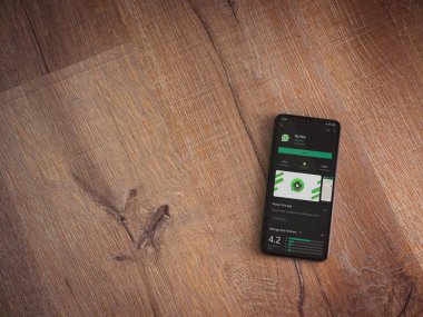 Lod, Israel - 8 Temmuz 2020: Scriby uygulama oyun mağazası sayfası ahşap arka planda siyah bir cep telefonunun ekranında. Üst görünüm düzlüğü kopyalama alanı ile yatıyordu.