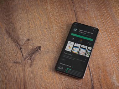 Lod, Israel - 8 Temmuz 2020: Daha sonra uygulama mağazası sayfası ahşap arka planda siyah bir cep telefonu görüntüsü. Üst görünüm düzlüğü kopyalama alanı ile yatıyordu.