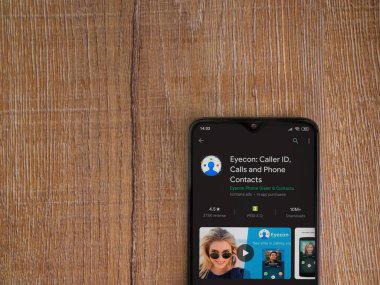 Lod, Israel - 8 Temmuz 2020: Eyecon uygulama oyun mağazası sayfası ahşap arka planda siyah bir cep telefonu ekranında. Üst görünüm düzlüğü kopyalama alanı ile yatıyordu.