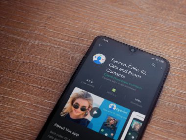 Lod, Israel - 8 Temmuz 2020: Eyecon uygulama oyun mağazası sayfası ahşap arka planda siyah bir cep telefonu ekranında. Üst görünüm düzlüğü kopyalama alanı ile yatıyordu.
