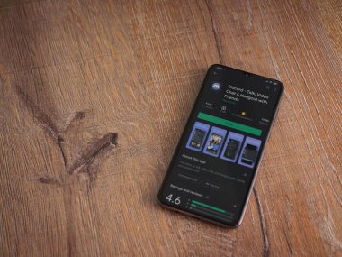Lod, Israel - 8 Temmuz 2020: Ahşap arka planda siyah bir cep telefonu ekranında Discord uygulaması oyun mağazası sayfası. Üst görünüm düzlüğü kopyalama alanı ile yatıyordu.