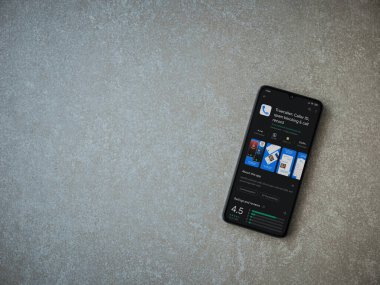 Lod, Israel - 8 Temmuz 2020: Truecaller uygulaması oyun mağazası sayfası seramik taş zemin üzerinde siyah bir cep telefonu görüntüsü. Üst görünüm düzlüğü kopyalama alanı ile yatıyordu.
