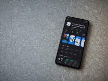 Lod, Israel - 8 Temmuz 2020: Truecaller uygulaması oyun mağazası sayfası seramik taş zemin üzerinde siyah bir cep telefonu görüntüsü. Üst görünüm düzlüğü kopyalama alanı ile yatıyordu.