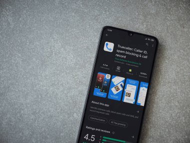Lod, Israel - 8 Temmuz 2020: Truecaller uygulaması oyun mağazası sayfası seramik taş zemin üzerinde siyah bir cep telefonu görüntüsü. Üst görünüm düzlüğü kopyalama alanı ile yatıyordu.