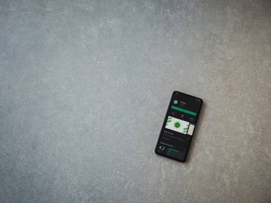 Lod, Israel - 8 Temmuz 2020: Scriby uygulama oyun mağazası sayfası seramik taş zemin üzerinde siyah bir cep telefonu görüntüsü. Üst görünüm düzlüğü kopyalama alanı ile yatıyordu.