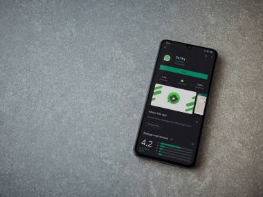 Lod, Israel - 8 Temmuz 2020: Scriby uygulama oyun mağazası sayfası seramik taş zemin üzerinde siyah bir cep telefonu görüntüsü. Üst görünüm düzlüğü kopyalama alanı ile yatıyordu.