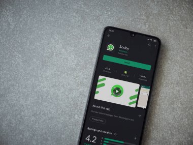 Lod, Israel - 8 Temmuz 2020: Scriby uygulama oyun mağazası sayfası seramik taş zemin üzerinde siyah bir cep telefonu görüntüsü. Üst görünüm düzlüğü kopyalama alanı ile yatıyordu.