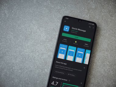 Lod, Israel - 8 Temmuz 2020: Hızlı Mesaj uygulaması oyun mağazası sayfası seramik taş zemin üzerinde siyah bir cep telefonu görüntüsü. Üst görünüm düzlüğü kopyalama alanı ile yatıyordu.