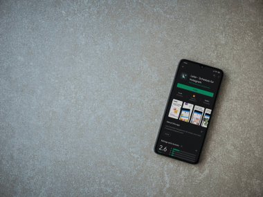 Lod, Israel - 8 Temmuz 2020: Daha sonra uygulamalı oyun mağazası sayfası seramik taş zemin üzerinde siyah bir cep telefonu görüntüsü. Üst görünüm düzlüğü kopyalama alanı ile yatıyordu.