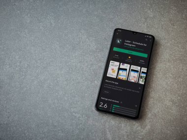 Lod, Israel - 8 Temmuz 2020: Daha sonra uygulamalı oyun mağazası sayfası seramik taş zemin üzerinde siyah bir cep telefonu görüntüsü. Üst görünüm düzlüğü kopyalama alanı ile yatıyordu.