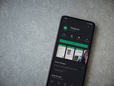 Lod, Israel - 8 Temmuz 2020: Hanghouts uygulaması oyun mağazası sayfası seramik taş zemin üzerinde siyah bir cep telefonu görüntüsü. Üst görünüm düzlüğü kopyalama alanı ile yatıyordu.