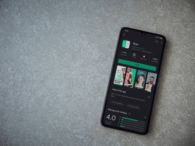 Lod, Israel - 8 Temmuz 2020: Azar uygulama oyun mağazası sayfası seramik taş zemin üzerinde siyah bir cep telefonu ekranında. Üst görünüm düzlüğü kopyalama alanı ile yatıyordu.