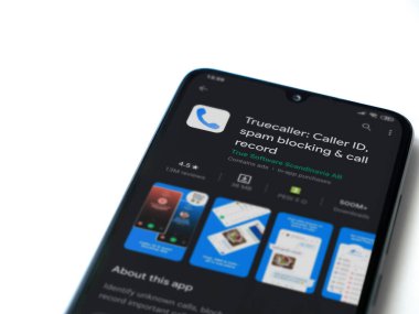 Lod, Israel - 8 Temmuz 2020: Truecaller uygulaması oyun mağazası sayfası beyaz arkaplanda izole edilmiş siyah bir cep telefonu ekranında. Üst görünüm düzlüğü kopyalama alanı ile yatıyordu.