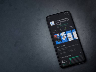 Lod, Israel - 8 Temmuz 2020: Truecaller uygulaması oyun mağazası sayfası koyu mermer taştan arka planda siyah bir cep telefonunun ekranında. Üst görünüm düzlüğü kopyalama alanı ile yatıyordu.