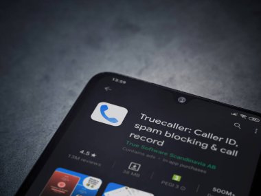 Lod, Israel - 8 Temmuz 2020: Truecaller uygulaması oyun mağazası sayfası koyu mermer taştan arka planda siyah bir cep telefonunun ekranında. Üst görünüm düzlüğü kopyalama alanı ile yatıyordu.