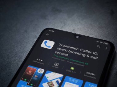 Lod, Israel - 8 Temmuz 2020: Truecaller uygulaması oyun mağazası sayfası koyu mermer taştan arka planda siyah bir cep telefonunun ekranında. Üst görünüm düzlüğü kopyalama alanı ile yatıyordu.