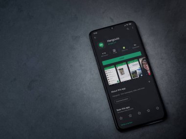 Lod, Israel - 8 Temmuz 2020: Hanghouts uygulaması oyun mağazası sayfası koyu mermer taştan arka planda siyah bir cep telefonunun ekranında. Üst görünüm düzlüğü kopyalama alanı ile yatıyordu.