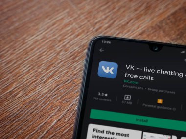 Lod, Israel - 8 Temmuz 2020: VK uygulama oyun mağazası sayfası ahşap arka planda siyah bir cep telefonunun ekranında. Üst görünüm düzlüğü kopyalama alanı ile yatıyordu.