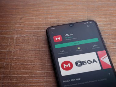 Lod, Israel - 8 Temmuz 2020: MeGA uygulama oyun mağazası sayfası ahşap arka planda siyah bir cep telefonunun ekranında. Üst görünüm düzlüğü kopyalama alanı ile yatıyordu.
