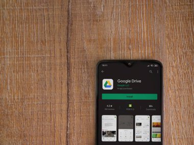 Lod, Israel - 8 Temmuz 2020: Google Drive uygulama oyun mağazası sayfası ahşap arka planda siyah bir cep telefonu görüntüsü. Üst görünüm düzlüğü kopyalama alanı ile yatıyordu.