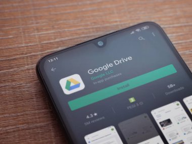 Lod, Israel - 8 Temmuz 2020: Google Drive uygulama oyun mağazası sayfası ahşap arka planda siyah bir cep telefonu görüntüsü. Üst görünüm düzlüğü kopyalama alanı ile yatıyordu.
