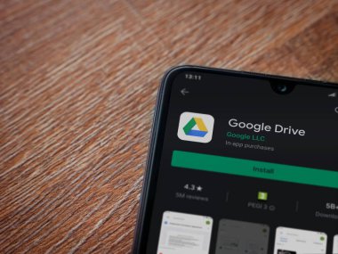 Lod, Israel - 8 Temmuz 2020: Google Drive uygulama oyun mağazası sayfası ahşap arka planda siyah bir cep telefonu görüntüsü. Üst görünüm düzlüğü kopyalama alanı ile yatıyordu.