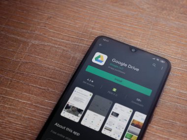 Lod, Israel - 8 Temmuz 2020: Google Drive uygulama oyun mağazası sayfası ahşap arka planda siyah bir cep telefonu görüntüsü. Üst görünüm düzlüğü kopyalama alanı ile yatıyordu.