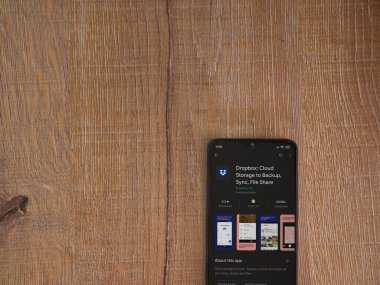 Lod, Israel - 8 Temmuz 2020: Dropbox uygulaması oyun mağazası sayfası ahşap arka planda siyah bir cep telefonunun ekranında. Üst görünüm düzlüğü kopyalama alanı ile yatıyordu.